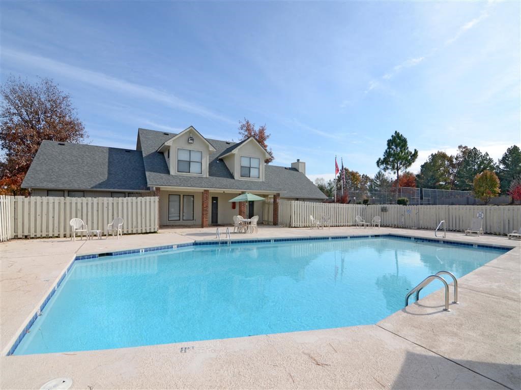a swimming pool with a house in the background
