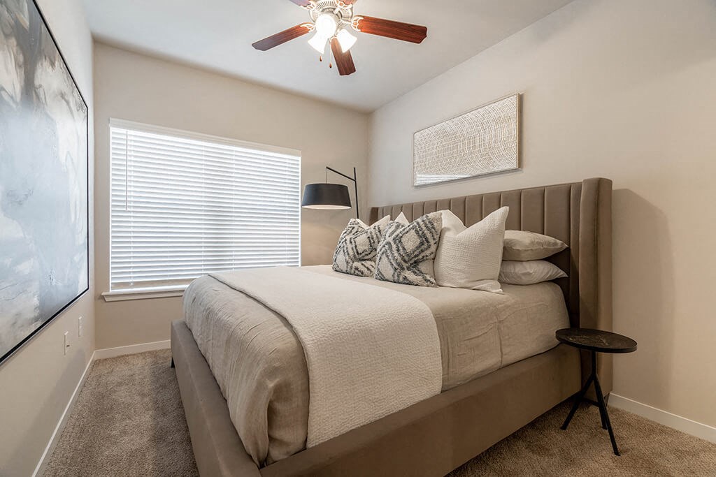 a bedroom with a bed and a ceiling fan