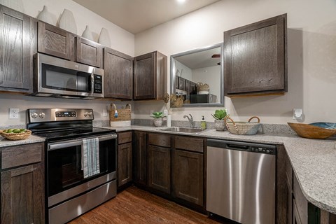A kitchen with dark wood cabinets and stainless steel appliances.