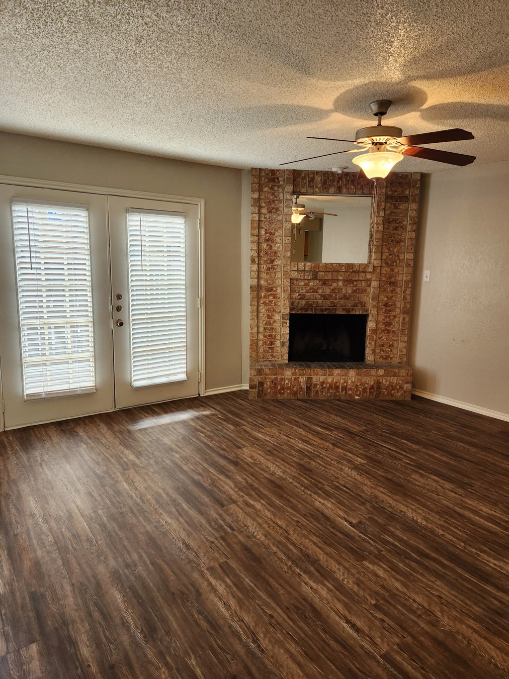 Delmar villas living room with a fireplace and a ceiling fan