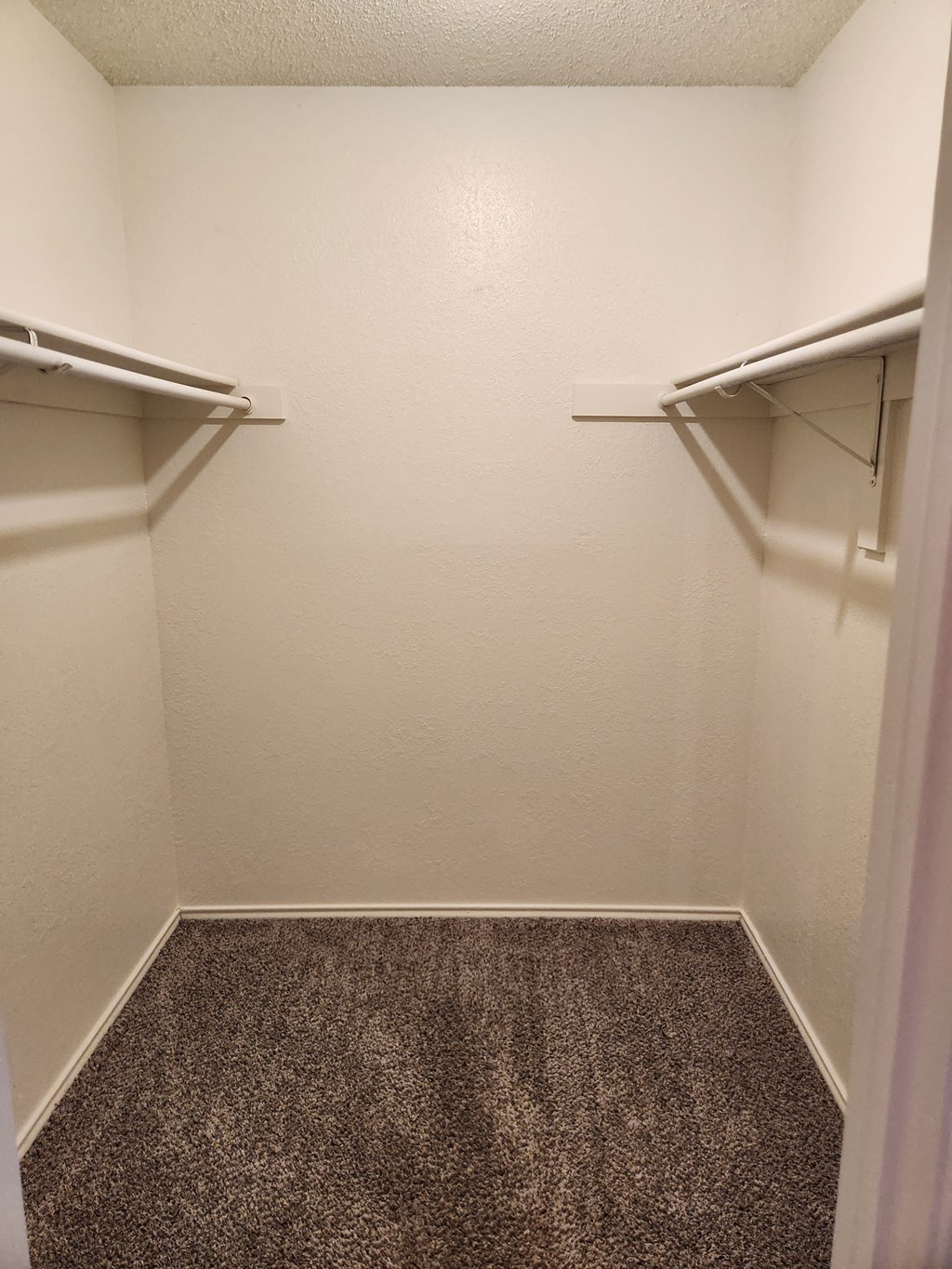 a small room with two empty shelves and a carpeted floor