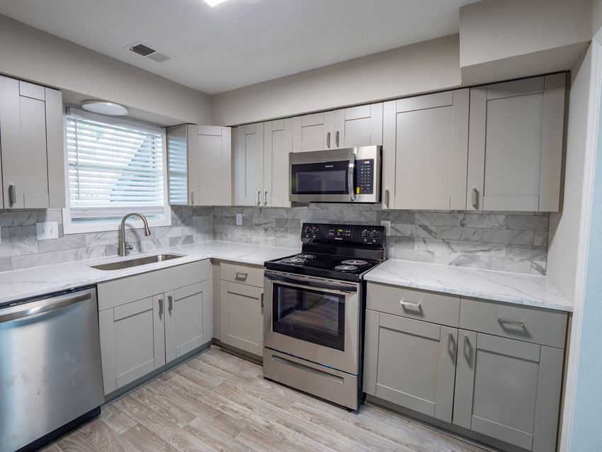 Manchester at Mansell Renovated Kitchens a kitchen with white cabinets and stainless steel appliances