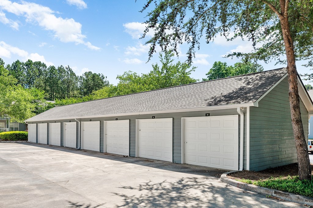 a row of garages with white doors on the side of a building