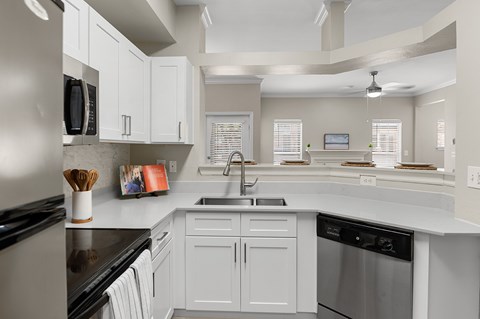 a kitchen with white cabinets and stainless steel appliances