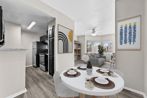 a dining room and living room with a white table and a kitchen