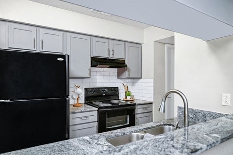 a kitchen with granite counter tops and black appliances