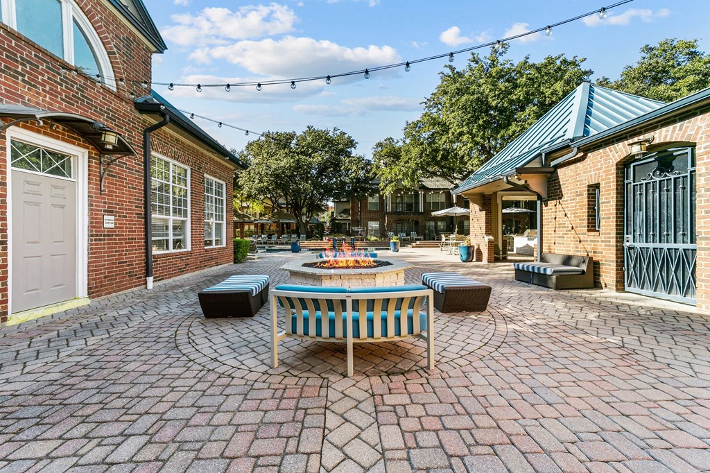 a patio with a table and chairs and a fire pit