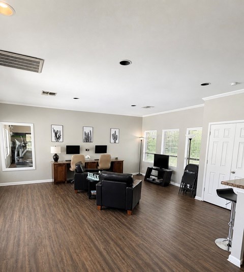 A living room with a couch, chairs, and a television.