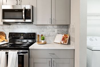 a kitchen with stainless steel appliances and white cabinets