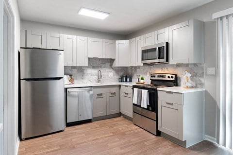 a kitchen with stainless steel appliances and white cabinets