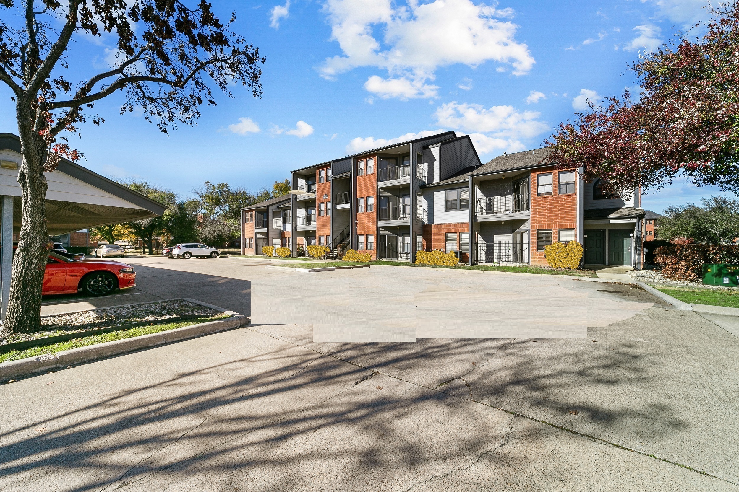 an empty parking lot in front of an apartment building