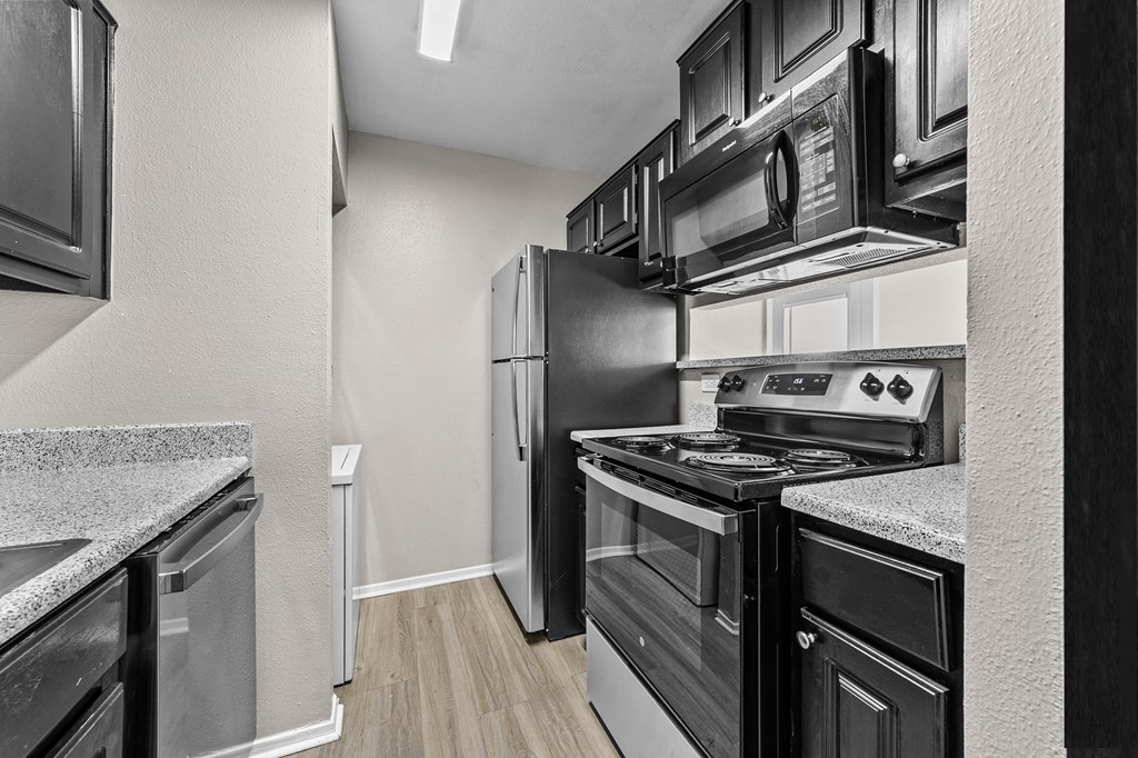 a kitchen with black and white appliances and a stainless steel refrigerator