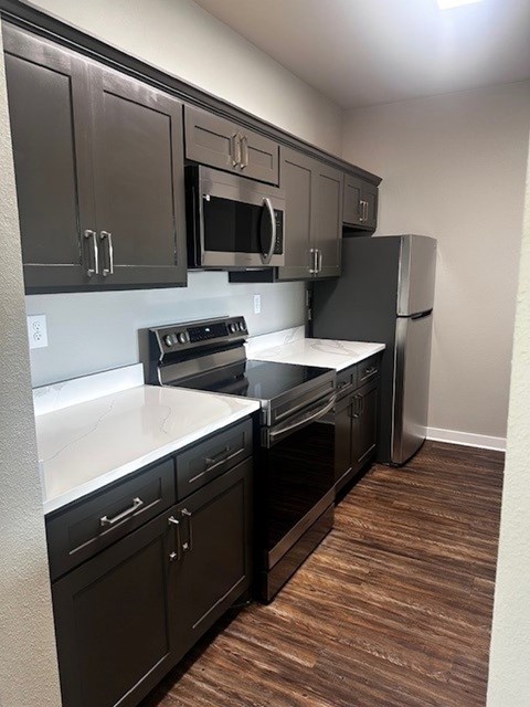 A kitchen with black cabinets and a white countertop.