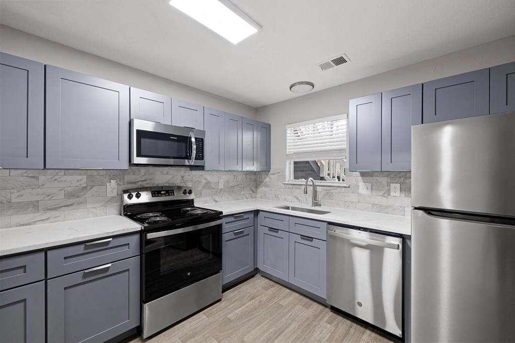 a kitchen with stainless steel appliances and white cabinets