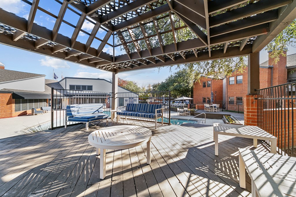 a patio with a table and chairs and a pool