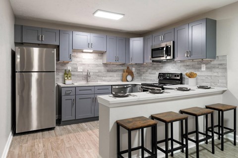 a kitchen with stainless steel appliances and a counter with four stools