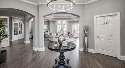 A modern living room with a black table and a chandelier.