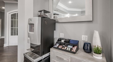 A modern kitchen with a black refrigerator and a wooden drawer.