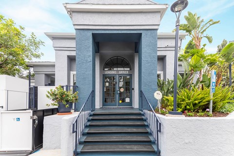 A building with a blue entrance and a sign that says "LEARNING OFFICE".