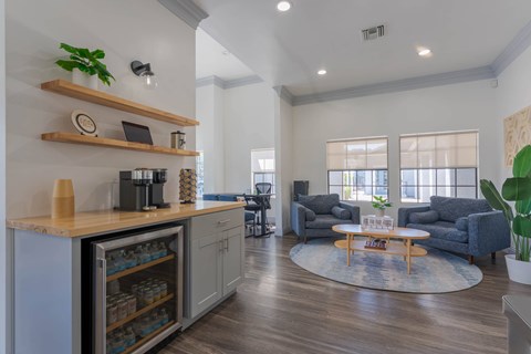 A kitchen with a refrigerator, a counter, and a dining area with chairs and a table.