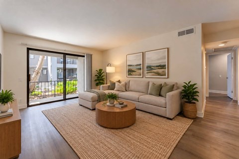 A living room with a couch, a coffee table, and a large window.
