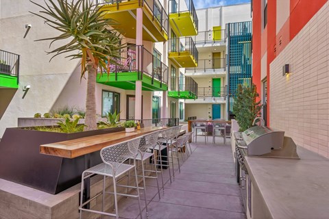 Outdoor courtyard with bar seating and grills at EVOC Apartments, California, 92103