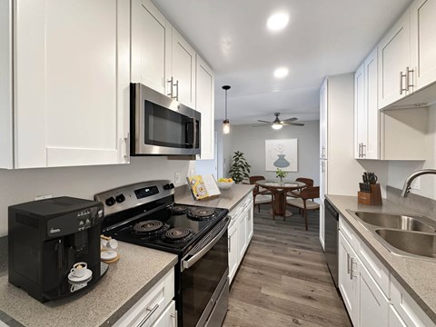 A modern kitchen with a black microwave and stove.