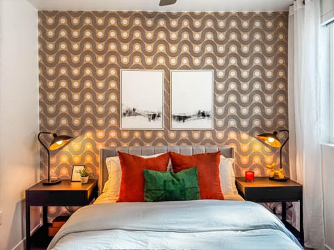 Bedroom with retro patterned wallpaper and orange accents at AMP 30 Apartments, San Diego, California