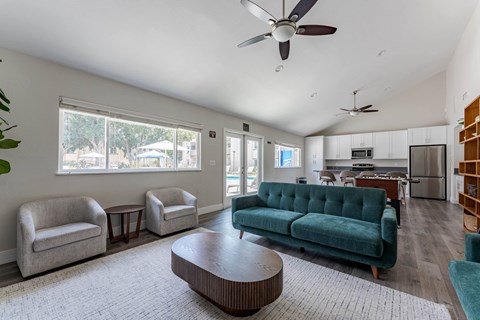 A living room with a green couch and a ceiling fan.