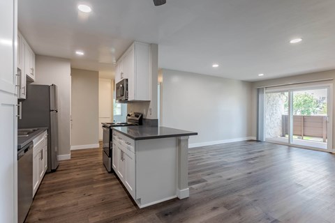 A kitchen with white cabinets and a black countertop.