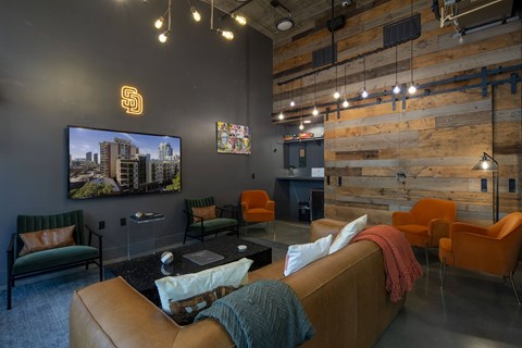 A living room with a couch, chairs, and a television.
