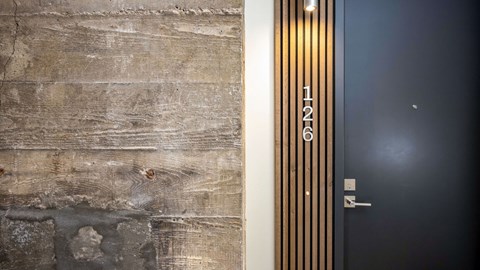 Apartment entrance door with vertical wood slat accents at TRU Bankers Hill Apartments, San Diego, CA