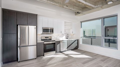 A modern kitchen with a stainless steel refrigerator and microwave.