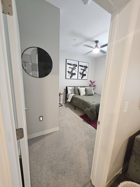 A bedroom with a bed and a ceiling fan.