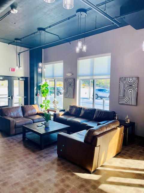 A living room with brown leather couches and a glass coffee table.