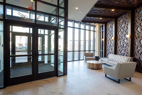 Contemporary lobby with decorative wood paneling and seating at Ten Front Apartments, Weymouth, MA
