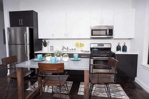A modern kitchen with a table set for two.