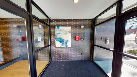 A hallway with a brick wall and a painting on it.