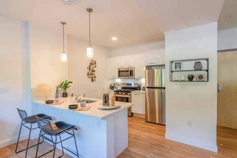 A kitchen with a white counter and a refrigerator.