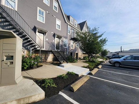 Exterior townhome entrance with metal stairs and parking area at 154 Granite Apartments, Quincy, MA 02169