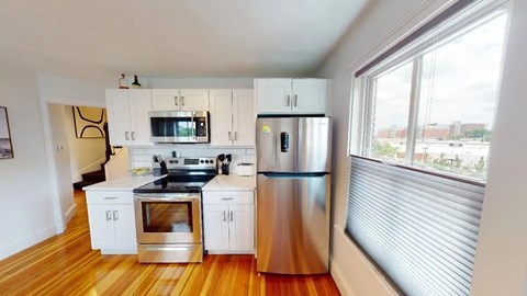 Bright kitchen with wood floors and panoramic window at 154 Granite Apartments, Quincy