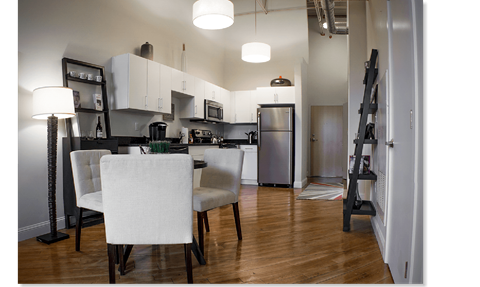 A kitchen with a dining table and chairs.