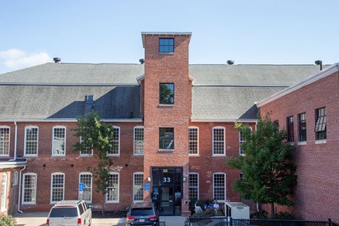 Historic brick courtyard with tower and parking at Star Mill Lofts Apartments, Massachusetts