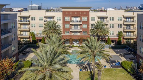 A large apartment complex with a pool in the middle.