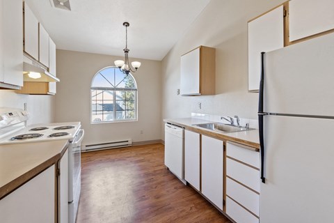 A kitchen with white appliances and wooden cabinets.