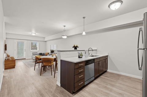 A modern kitchen with a wooden table and chairs.