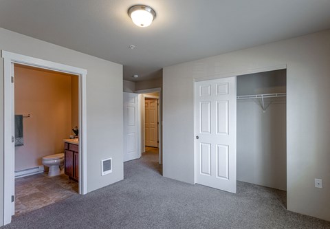 A spacious room with a toilet and sink visible through the open door.