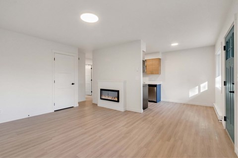 A spacious living room with a fireplace and hardwood floors.
