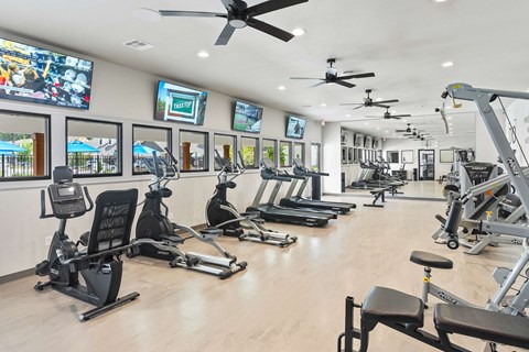 A gym with a variety of equipment including treadmills, stationary bikes, and weight machines.