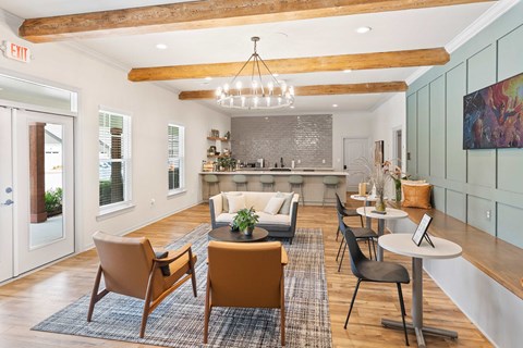 A modern living room with a dining area and a kitchen in the background.